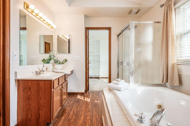 bathroom featuring a stall shower, visible vents, wood finished floors, a whirlpool tub, and vanity