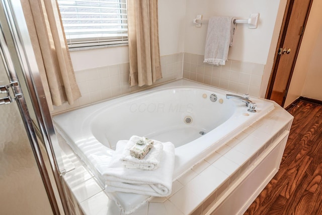 full bathroom with a whirlpool tub and wood finished floors