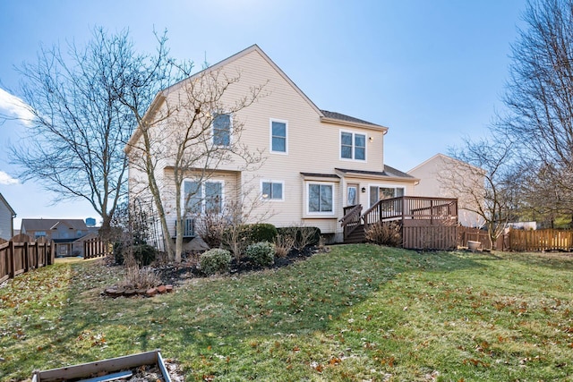 rear view of property featuring a yard, fence, and a wooden deck