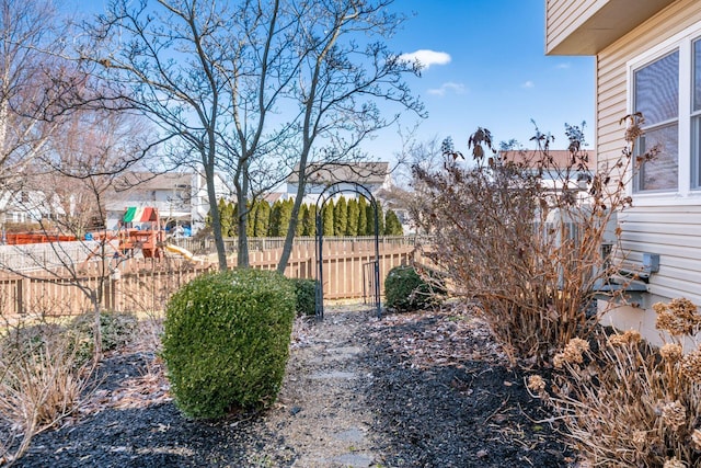 view of yard featuring fence and a playground