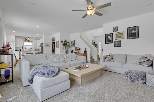 living room with ceiling fan, stairway, light colored carpet, and recessed lighting