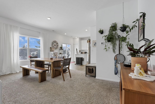 dining room with recessed lighting, light colored carpet, and baseboards