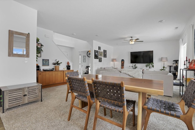 dining space featuring light carpet, ceiling fan, and visible vents