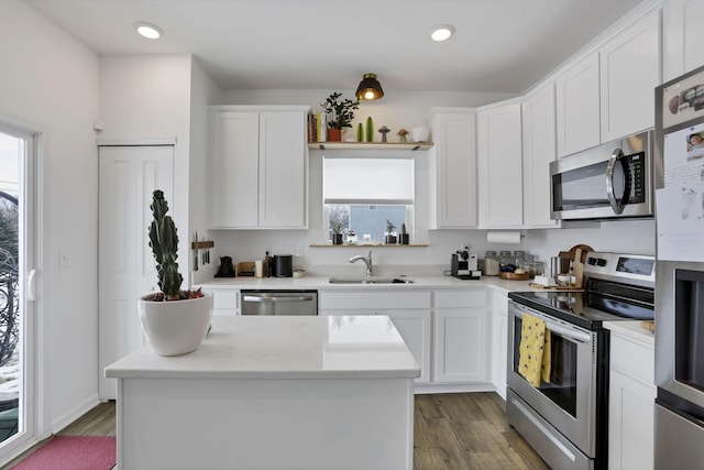 kitchen featuring stainless steel appliances, a sink, dark wood finished floors, and white cabinets