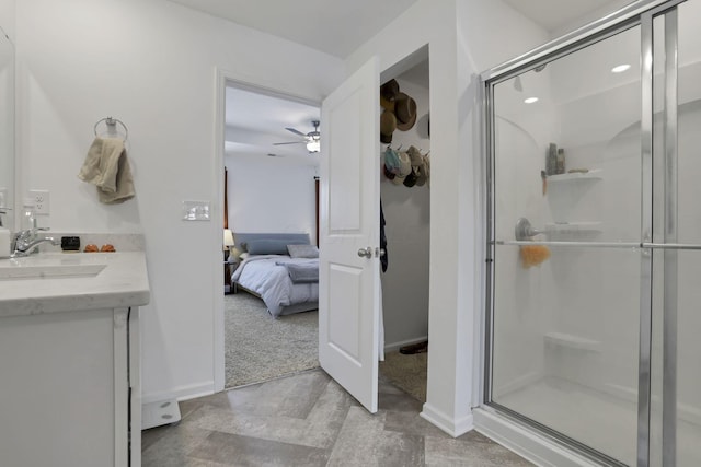 full bathroom featuring ensuite bathroom, a ceiling fan, vanity, baseboards, and a stall shower