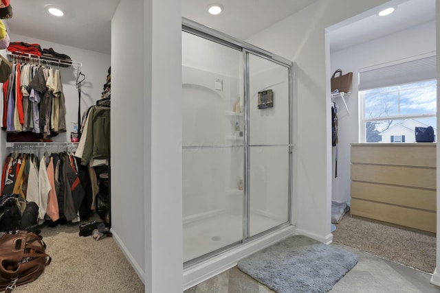 full bath featuring baseboards, recessed lighting, a walk in closet, and a shower stall