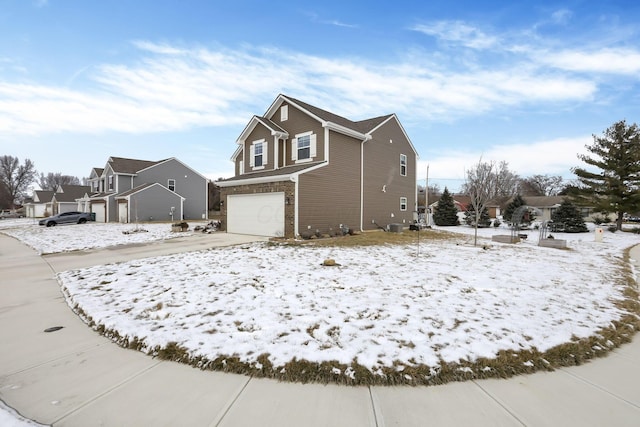 view of snow covered exterior with a residential view and an attached garage