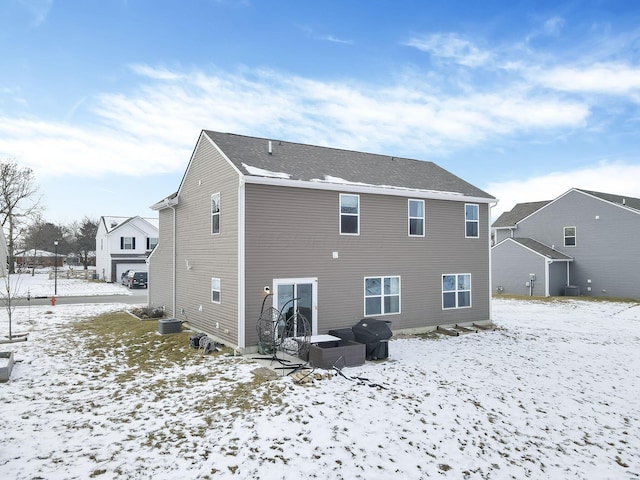 snow covered property featuring central AC unit