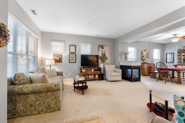 living room with plenty of natural light, carpet flooring, and a multi sided fireplace