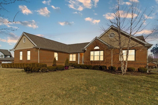 ranch-style home with brick siding and a lawn