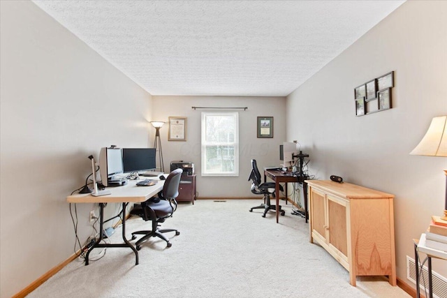 office area with baseboards, a textured ceiling, and light colored carpet