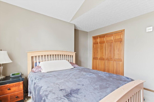 bedroom featuring lofted ceiling, a closet, and a textured ceiling