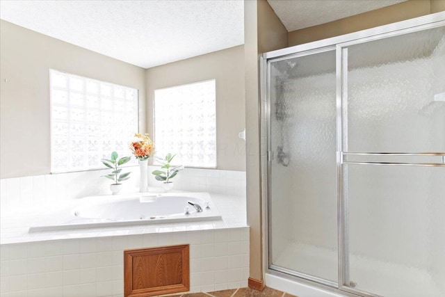 bathroom featuring a whirlpool tub, a textured ceiling, and a shower stall