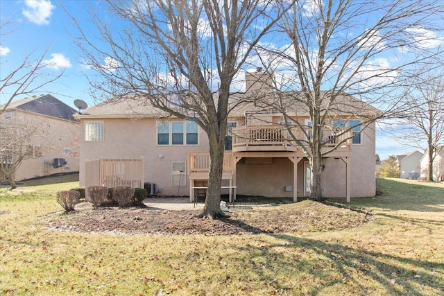 back of property featuring a yard, a chimney, a deck, and stucco siding