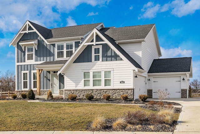 view of front of property featuring board and batten siding, stone siding, an attached garage, and concrete driveway