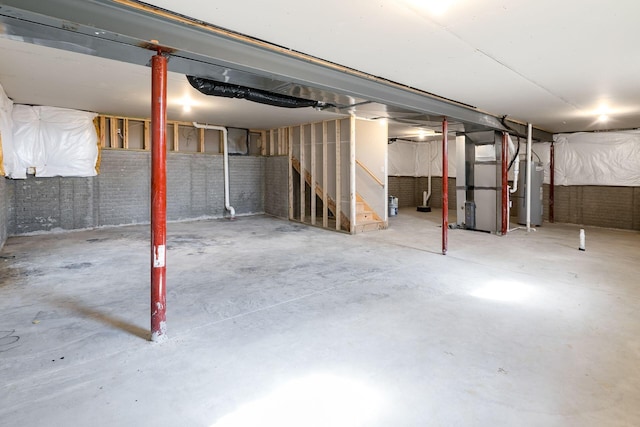 unfinished basement featuring water heater and heating unit