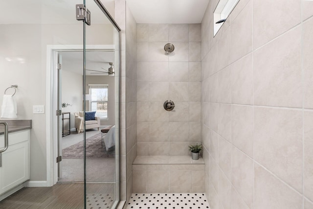 full bathroom featuring ceiling fan and a stall shower