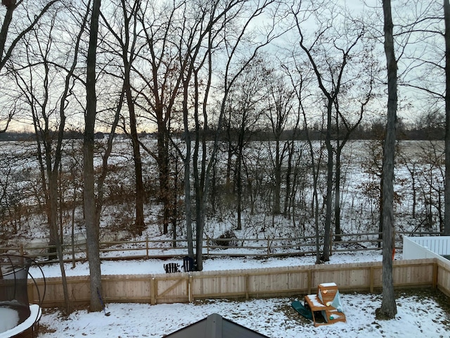 snowy yard featuring fence