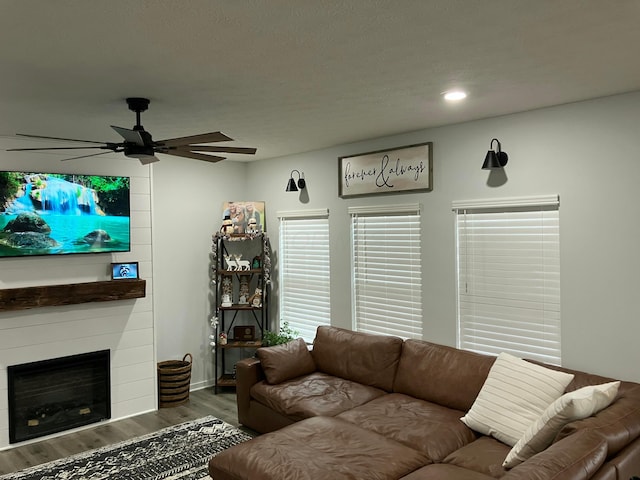 living room with a fireplace, wood finished floors, a ceiling fan, and recessed lighting