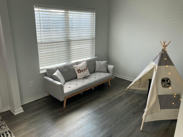 living area with dark wood-type flooring and baseboards