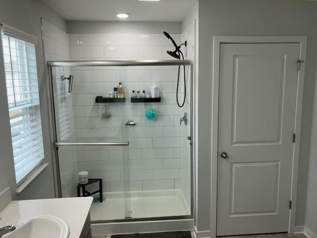 bathroom with a shower stall and vanity