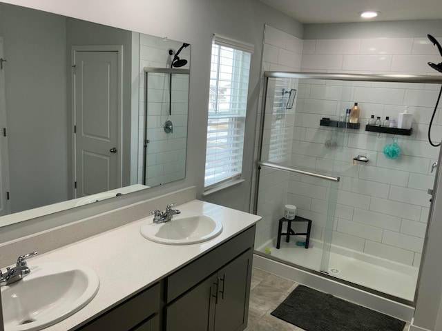 bathroom featuring a sink, a shower stall, and double vanity