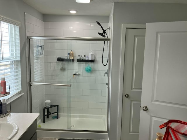 full bath with a stall shower and vanity