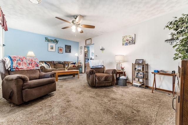 carpeted living area featuring a ceiling fan and baseboards