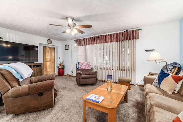 living room featuring baseboards, a textured ceiling, a ceiling fan, and carpet flooring