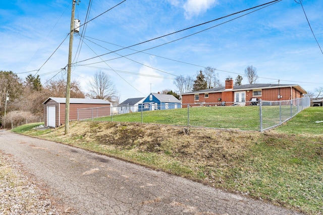 exterior space with a garage, driveway, an outdoor structure, and fence