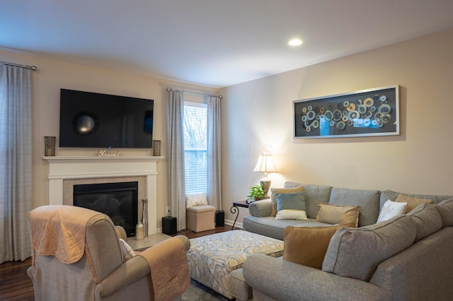 living room featuring recessed lighting, baseboards, wood finished floors, and a glass covered fireplace