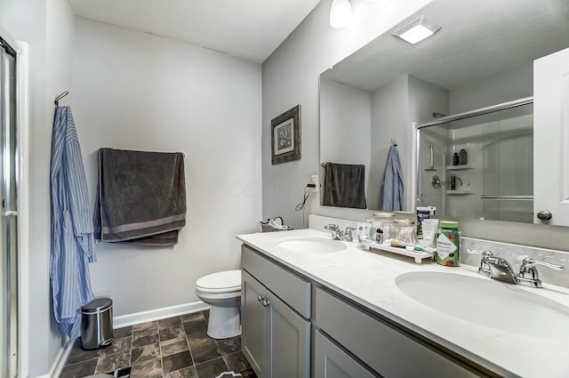 full bath featuring a stall shower, a sink, baseboards, and double vanity