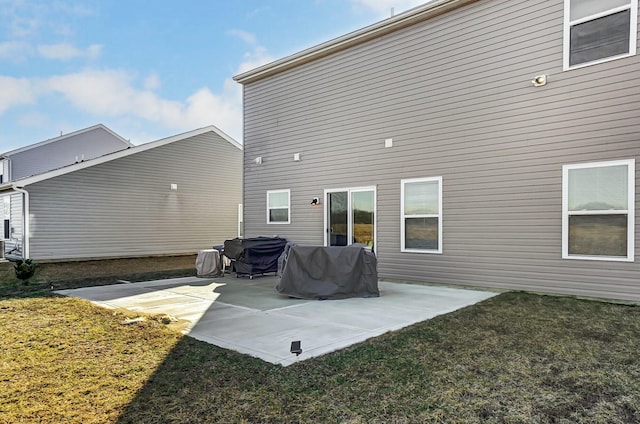 back of house with a patio area and a lawn