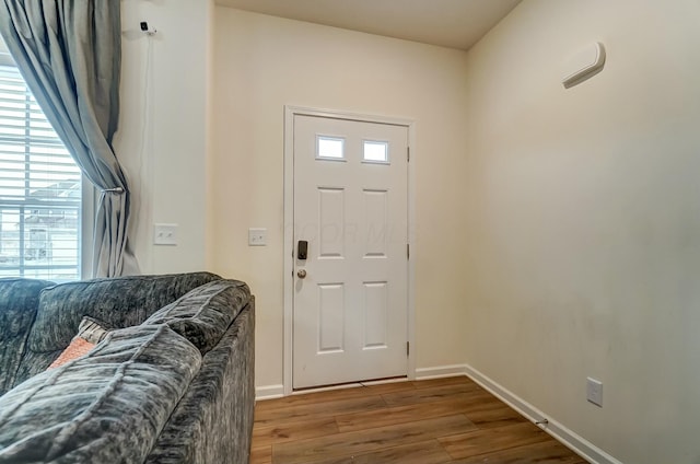 foyer with dark wood-type flooring and baseboards