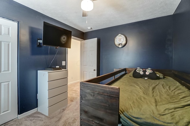 bedroom with a ceiling fan, baseboards, a textured ceiling, and light colored carpet