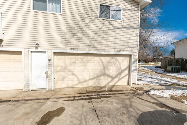 snow covered garage featuring central AC