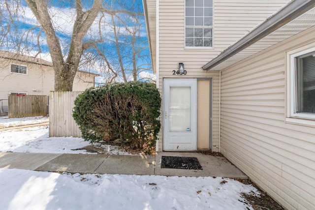 snow covered property entrance featuring fence