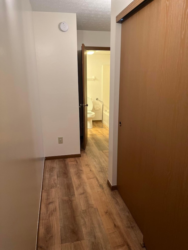 5885 Beechcroft Rd Unit 110, Columbus, OH 43229 - hallway with wood finished floors, a textured ceiling, and baseboards