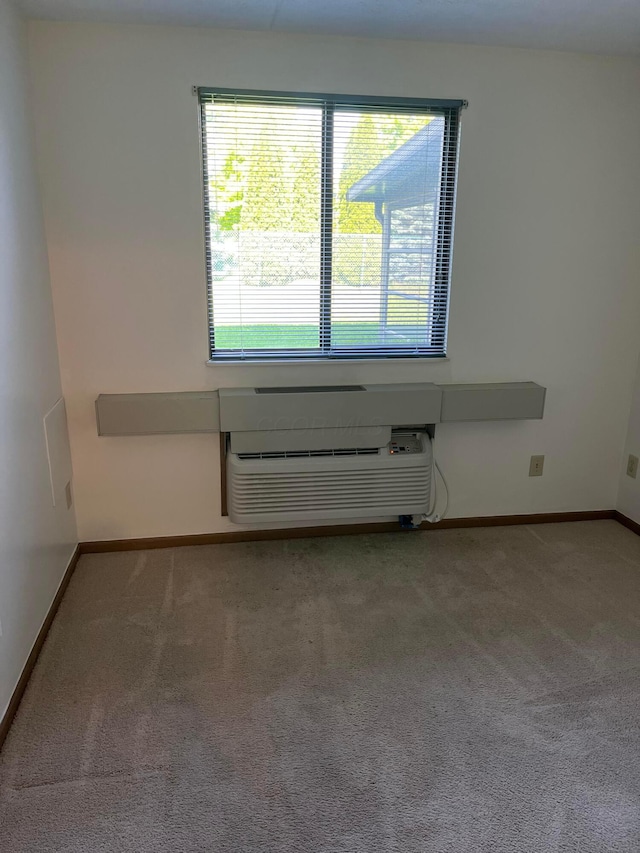 5885 Beechcroft Rd Unit 110, Columbus, OH 43229 - carpeted empty room with baseboards and a wall mounted air conditioner