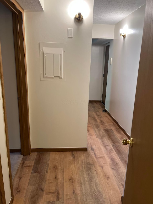 5885 Beechcroft Rd Unit 110, Columbus, OH 43229 - hallway with electric panel, wood finished floors, baseboards, and a textured ceiling