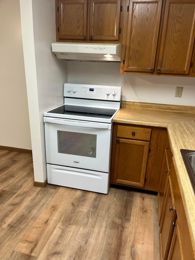 5885 Beechcroft Rd Unit 110, Columbus, OH 43229 - kitchen with under cabinet range hood, white range with electric cooktop, light wood-style floors, and light countertops