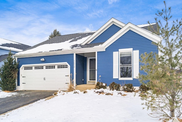 ranch-style home featuring a garage and aphalt driveway