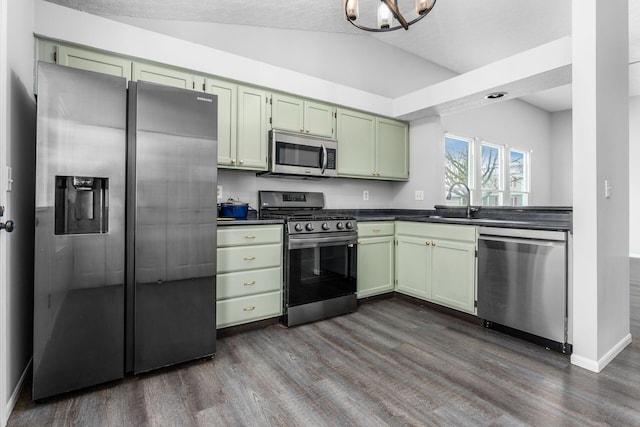 kitchen with appliances with stainless steel finishes, dark wood-style flooring, dark countertops, and green cabinetry