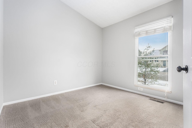 unfurnished room with baseboards, carpet, visible vents, and a wealth of natural light