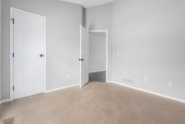 unfurnished bedroom featuring carpet flooring, visible vents, and baseboards