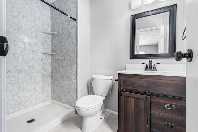 full bathroom featuring baseboards, toilet, tile patterned floors, vanity, and a shower stall