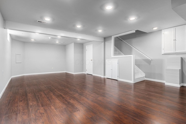 finished below grade area with recessed lighting, wood finished floors, visible vents, baseboards, and stairway