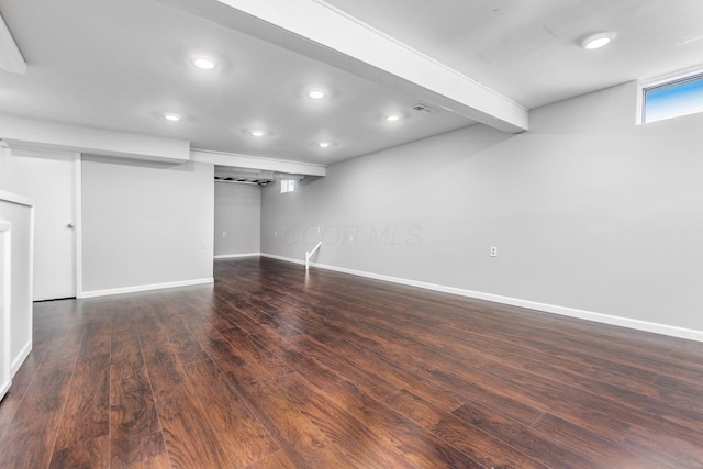 below grade area featuring recessed lighting, dark wood-style flooring, visible vents, and baseboards