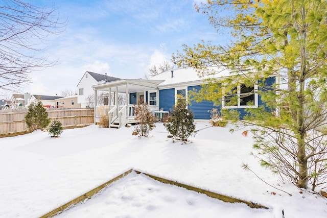 snow covered back of property with fence