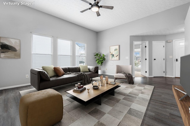 living area with ceiling fan, baseboards, a textured ceiling, and wood finished floors